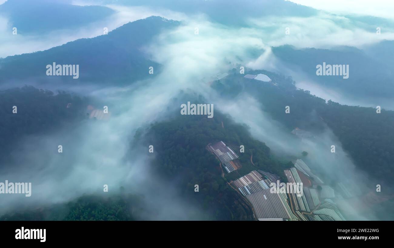 Vista aérea de los suburbios de Xuan Tho cerca de la ciudad de Da Lat por la mañana con cielo brumoso en las tierras altas de Vietnam. Textura de desarrollo urbano, transporte Foto de stock