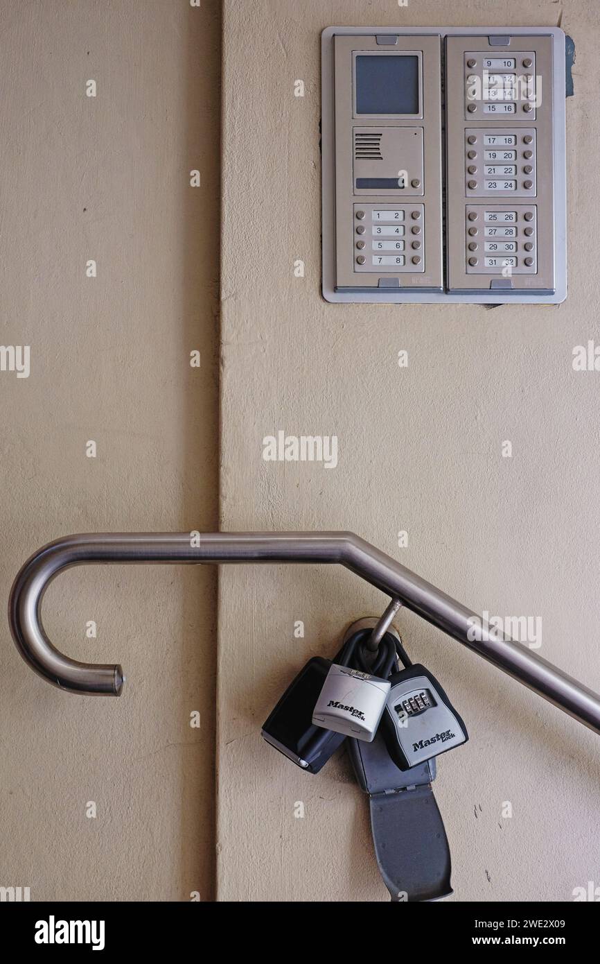 Apartamento intercomunicador en la pared por encima de la combinación de cerradura cajas de seguridad de llave en una barandilla de mano de metal, para Airbnb alquiler de apartamentos a corto plazo en Sydney Foto de stock