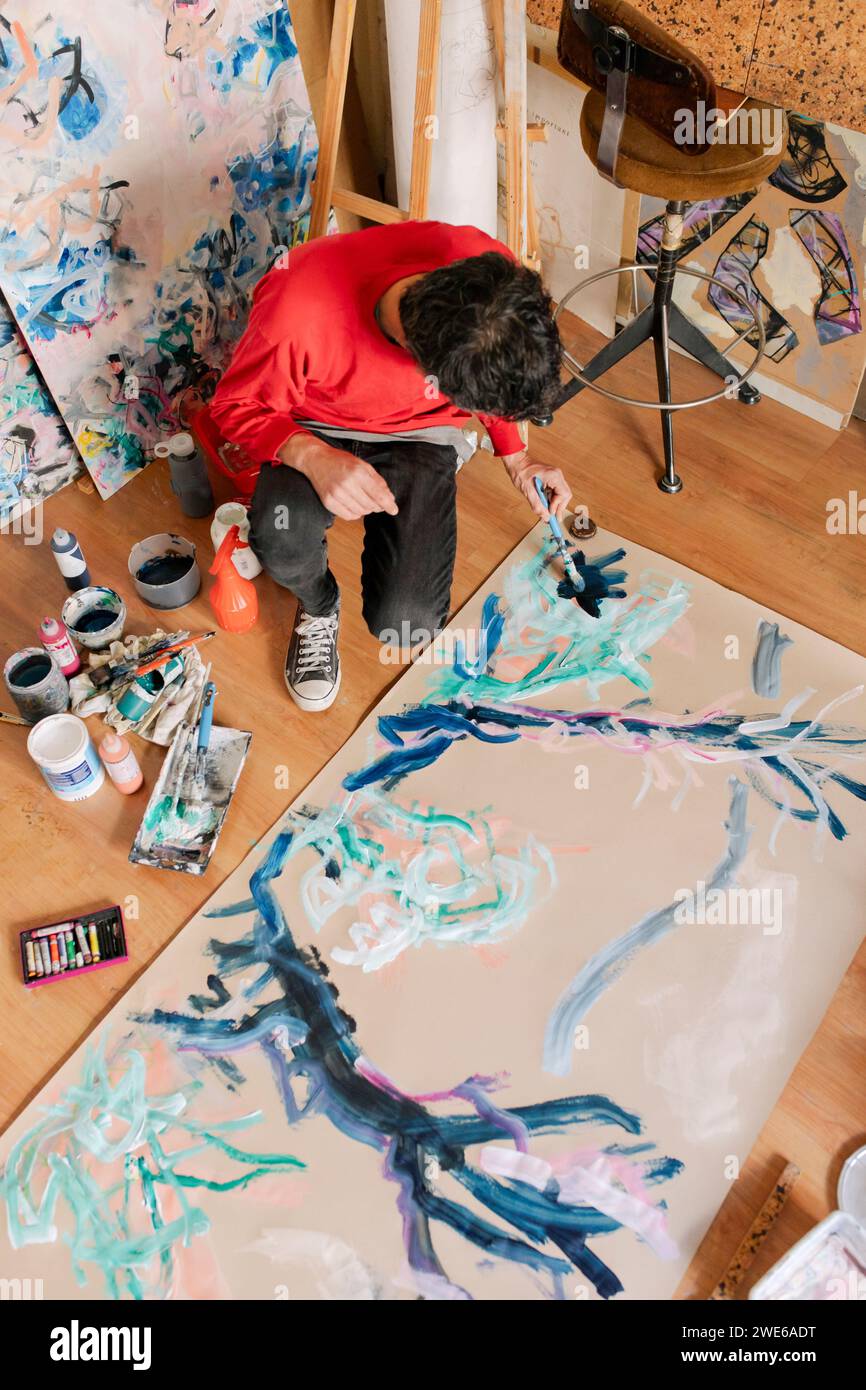 Artista maduro pintando sobre lienzo con pincel en estudio de arte Foto de stock