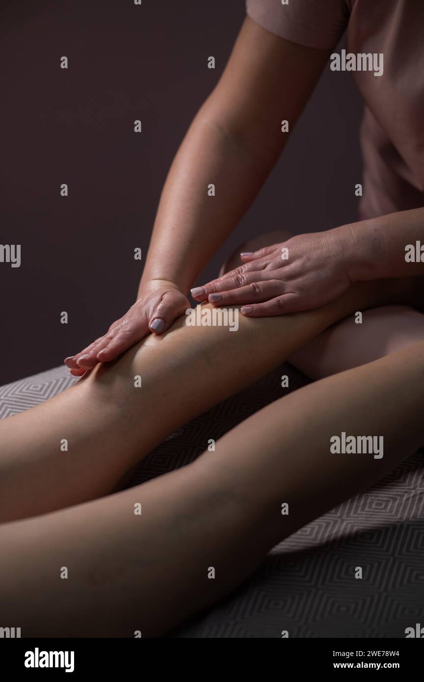 La mujer masajea los pies cansados en un vibrador masajeador de pies de agua.aislado  sobre fondo negro Fotografía de stock - Alamy