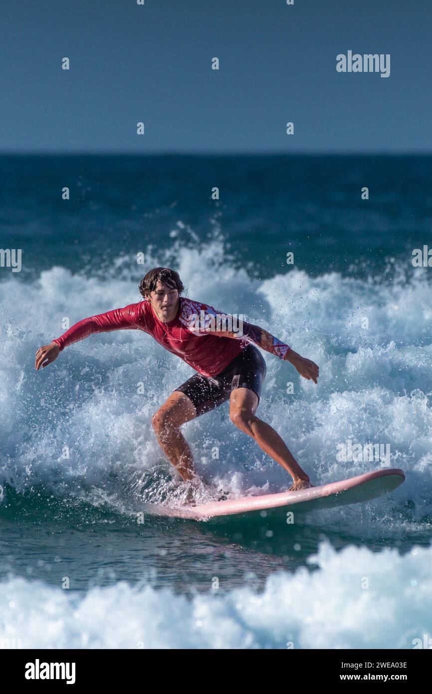 La acción espectacular del surf como surfista masculino monta una ola en Fistral en Newquay en Cornwall en Inglaterra en el Reino Unido. Foto de stock