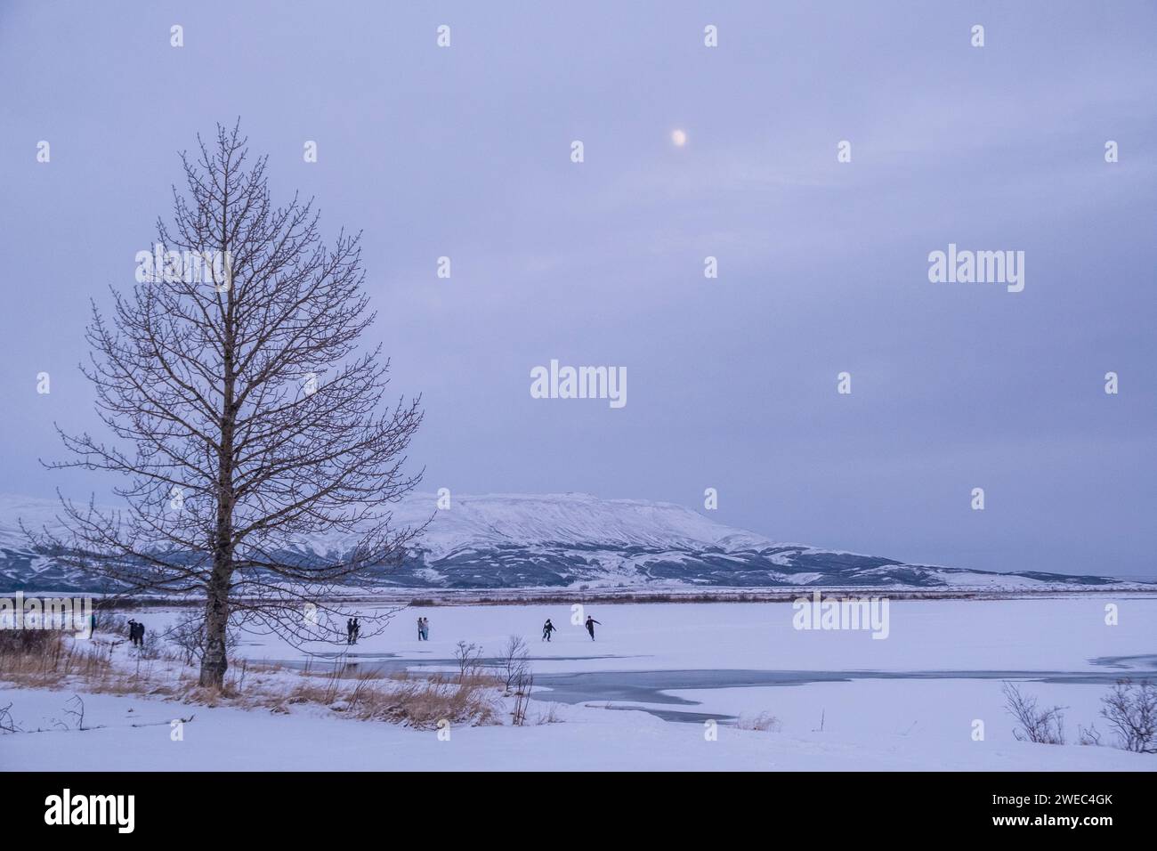 Patinadores en el hielo en Laugarvatn, Islandia, en una noche de invierno Foto de stock