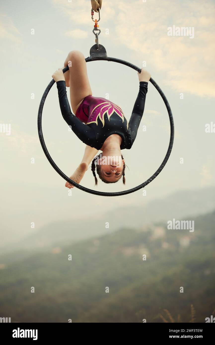 12 años de edad niña gimnasta actuando en aro aéreo al aire libre Foto de stock