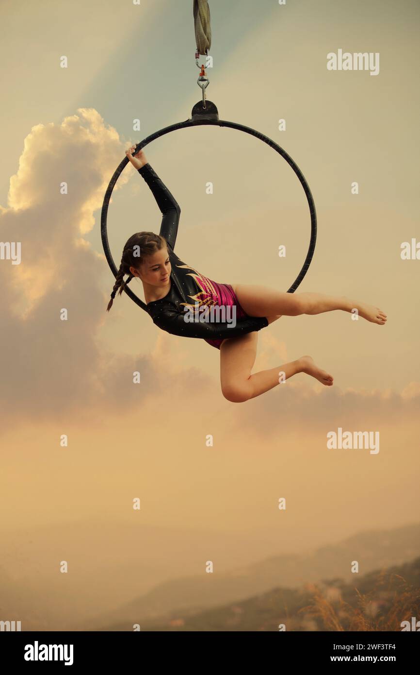 12 años de edad niña gimnasta actuando en aro aéreo al aire libre Foto de stock