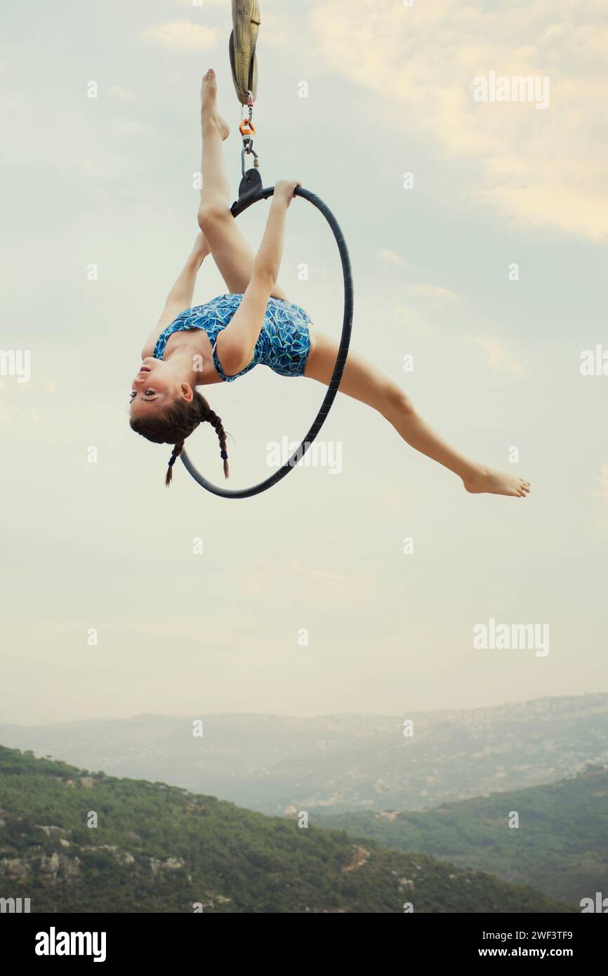 12 años de edad niña gimnasta actuando en aro aéreo al aire libre Foto de stock