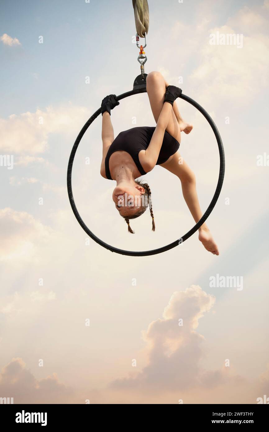 12 años de edad niña gimnasta actuando en aro aéreo al aire libre Foto de stock