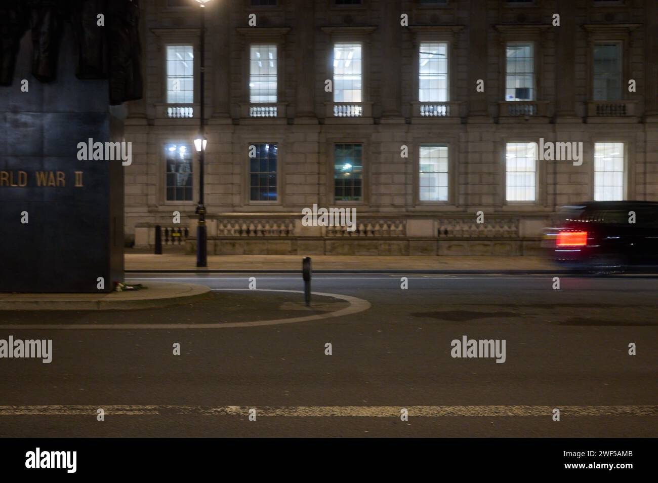 26 Ene 2024 - LondonUK: Parte del Monumento a las Mujeres de la Segunda Guerra Mundial en Whitehall en Londres por la noche con el coche que pasa en movimiento desenfoque Foto de stock