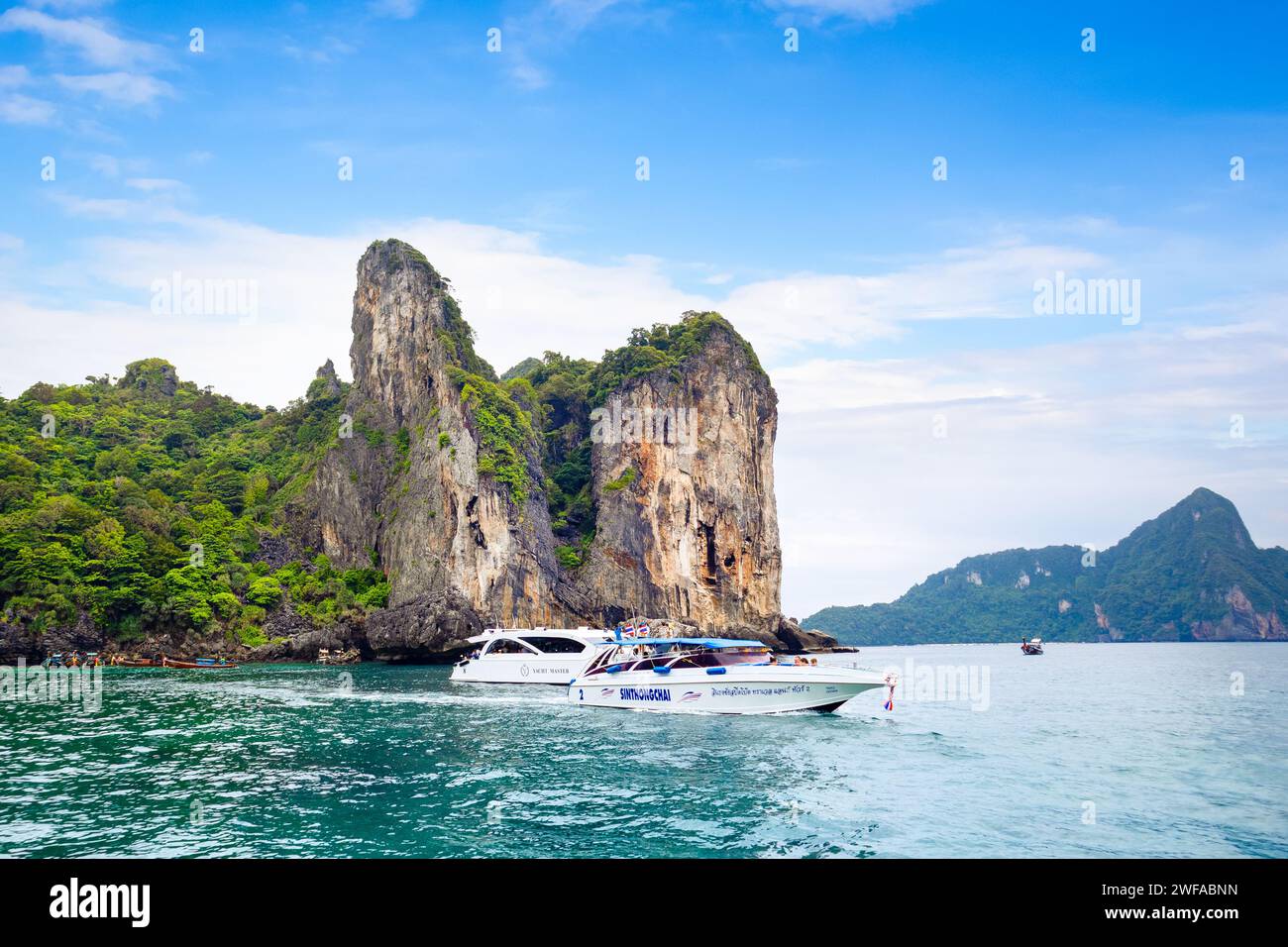 Phi Phi, Tailandia - 23 de noviembre de 2023: Barcos de crucero y yates cerca de las islas Phi Phi - uno de los lugares más famosos con vistas al paraíso y roca verde Foto de stock