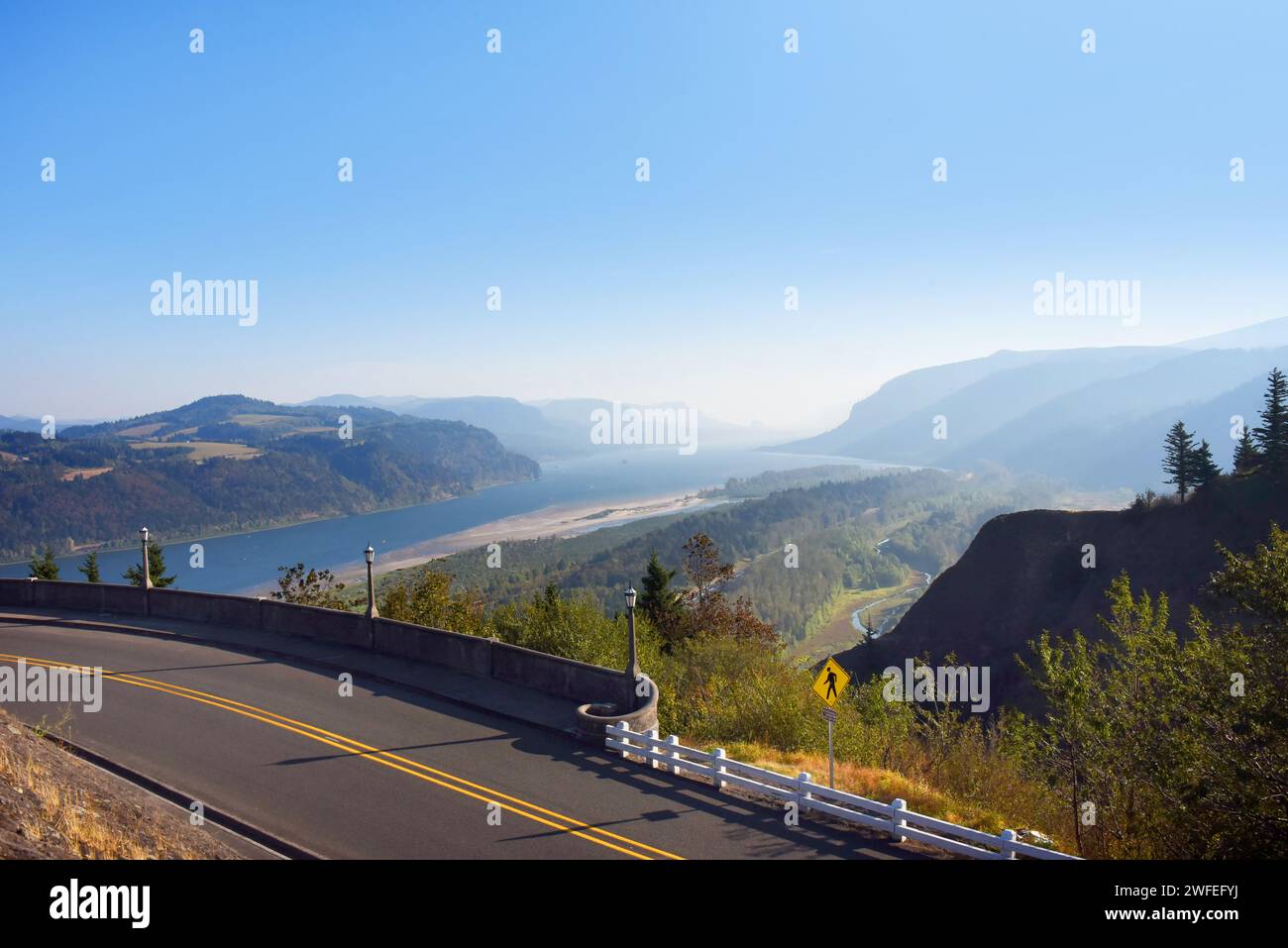 La carretera y la barandilla de piedra curva revelan una vista panorámica de la garganta del río Columbia, vista desde el Observatorio Vista House en Oregón. Foto de stock