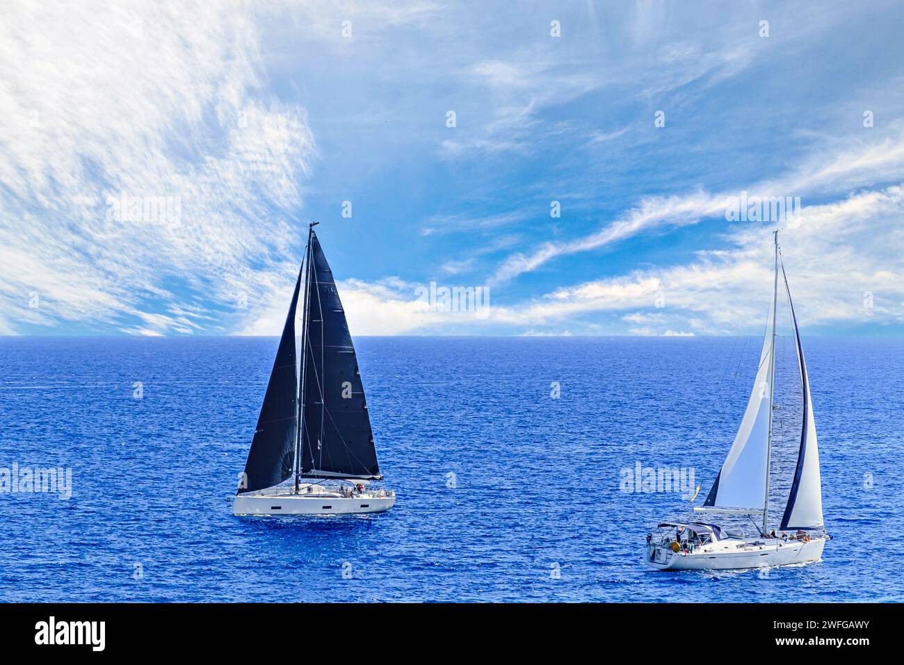 Barco, velero navegando en la playa de Mallorca bajo un cielo azul con nubes blancas Foto de stock