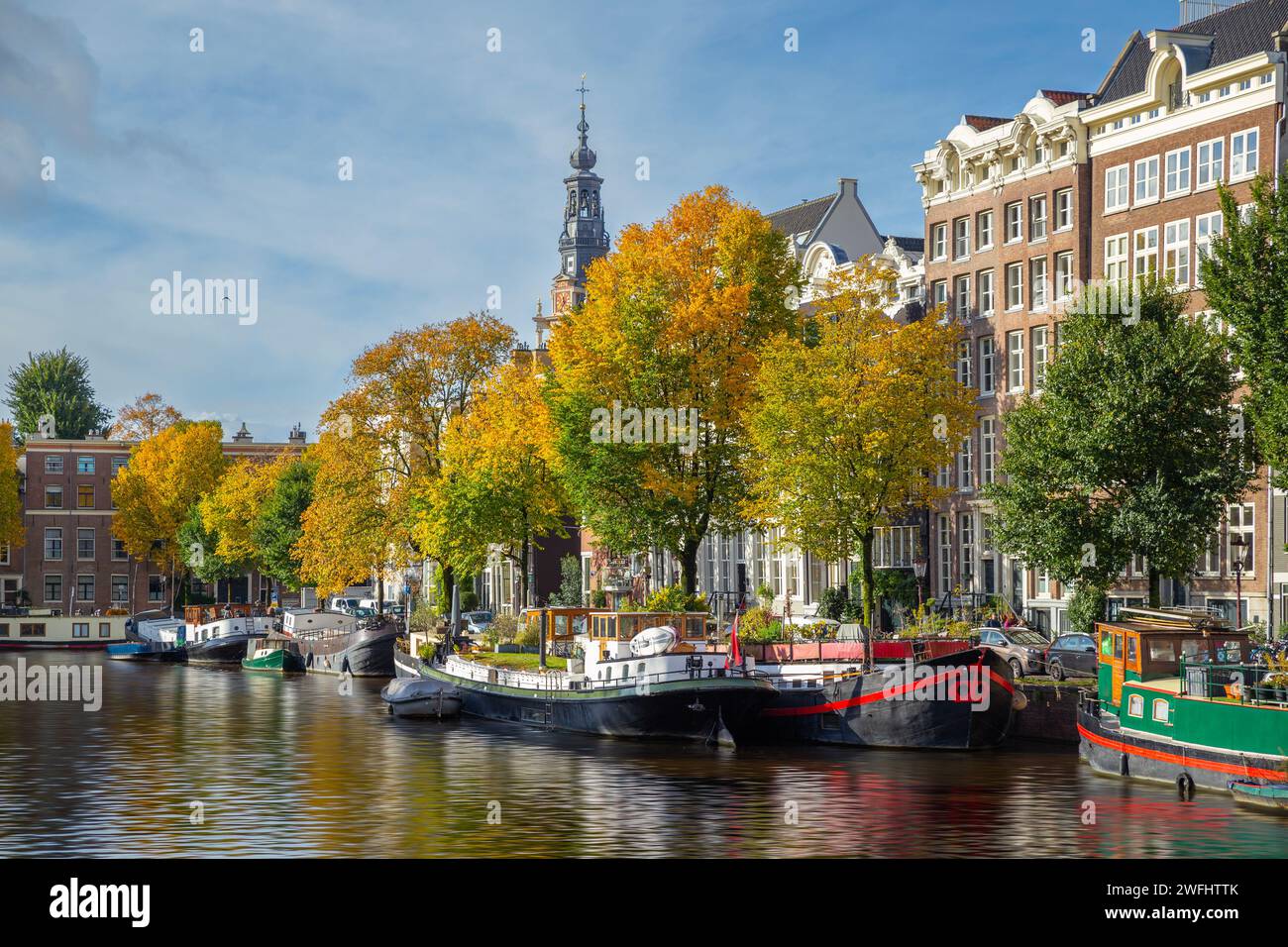 Canal de Ámsterdam y casa flotante / casa adosada con árboles coloridos de otoño, Amsterdam Foto de stock