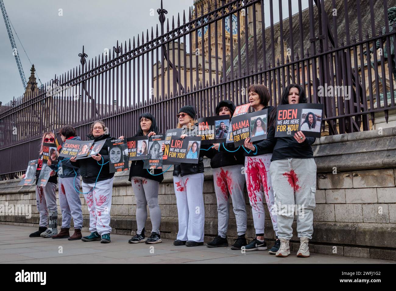Westminster, Londres, Reino Unido. 31 de enero de 2024. Un valiente grupo de mujeres se paró frente a las Cámaras del Parlamento, con pantalones manchados de sangre falsos y atados en las muñecas, mientras los parlamentarios y miembros de la Cámara de los Lores escuchaban testimonios de israelíes, testigos de la "mutilación genital deliberada y sistemática" durante los ataques de 7/10, y se enfrentaban a la muerte de los miembros de la Cámara de los Lores. en una reunión dentro. Naama Levy, una israelí de 19 años de edad, secuestrada en Gaza, fue vista por última vez siendo secuestrada con las manos atadas y los pantalones manchados de sangre, mostrando signos de violencia sexual. Fotografía Amanda Rose / Alamy Live News Foto de stock