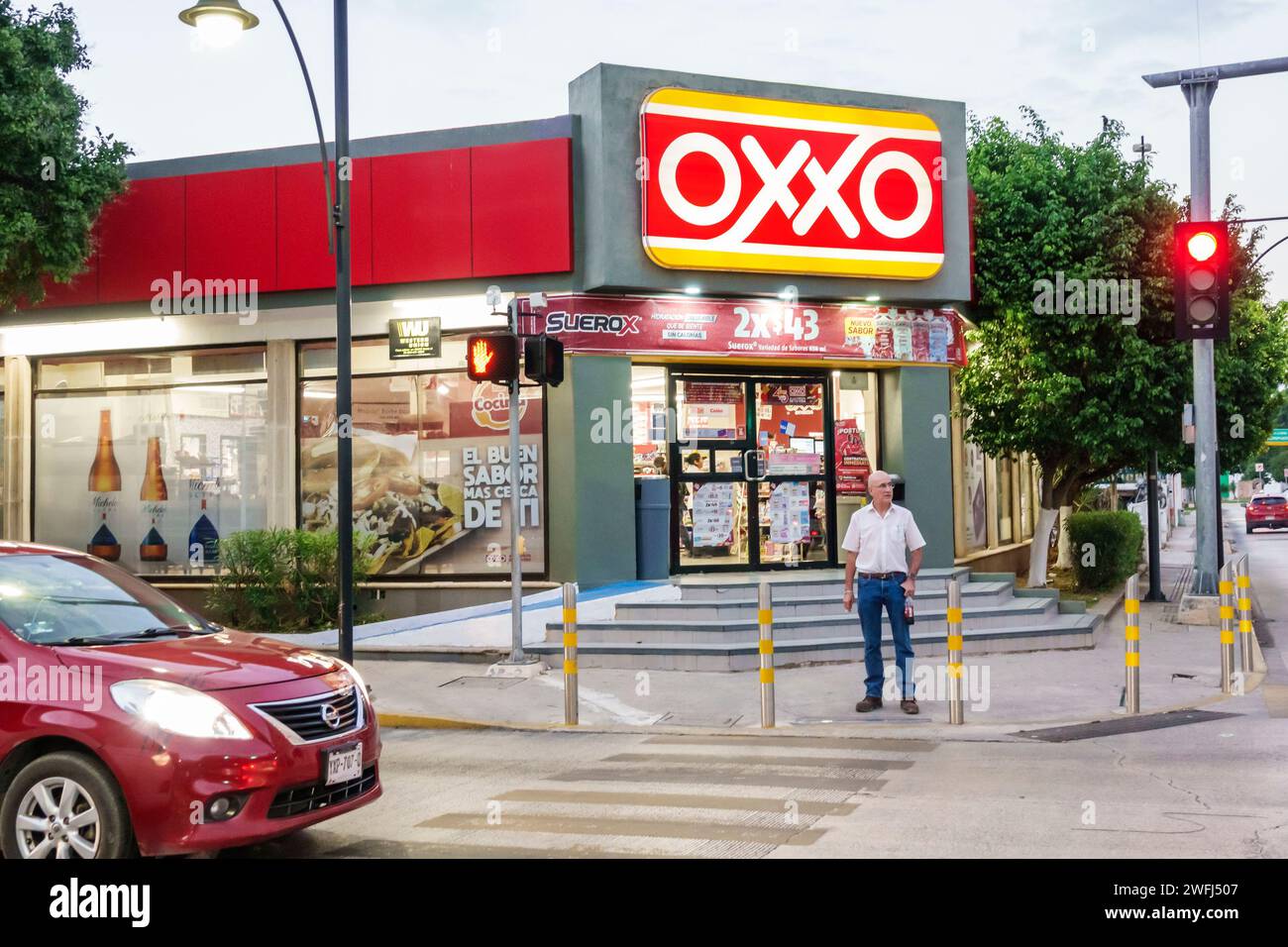 Mérida México, Centro, Oxxo tienda de alimentos de conveniencia bodega de negocios, exterior entrada delantera noche, hombre hombres, adultos, resid Foto de stock