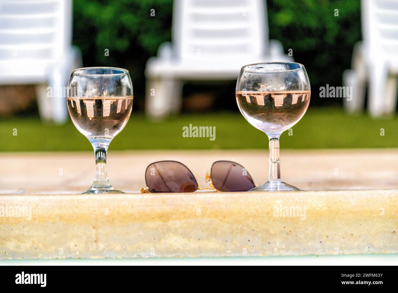 Hombre Con Gafas De Sol Sosteniendo Un Cóctel En La Piscina Cerca De Una  Novia Borrosa Fotos, retratos, imágenes y fotografía de archivo libres de  derecho. Image 172206117