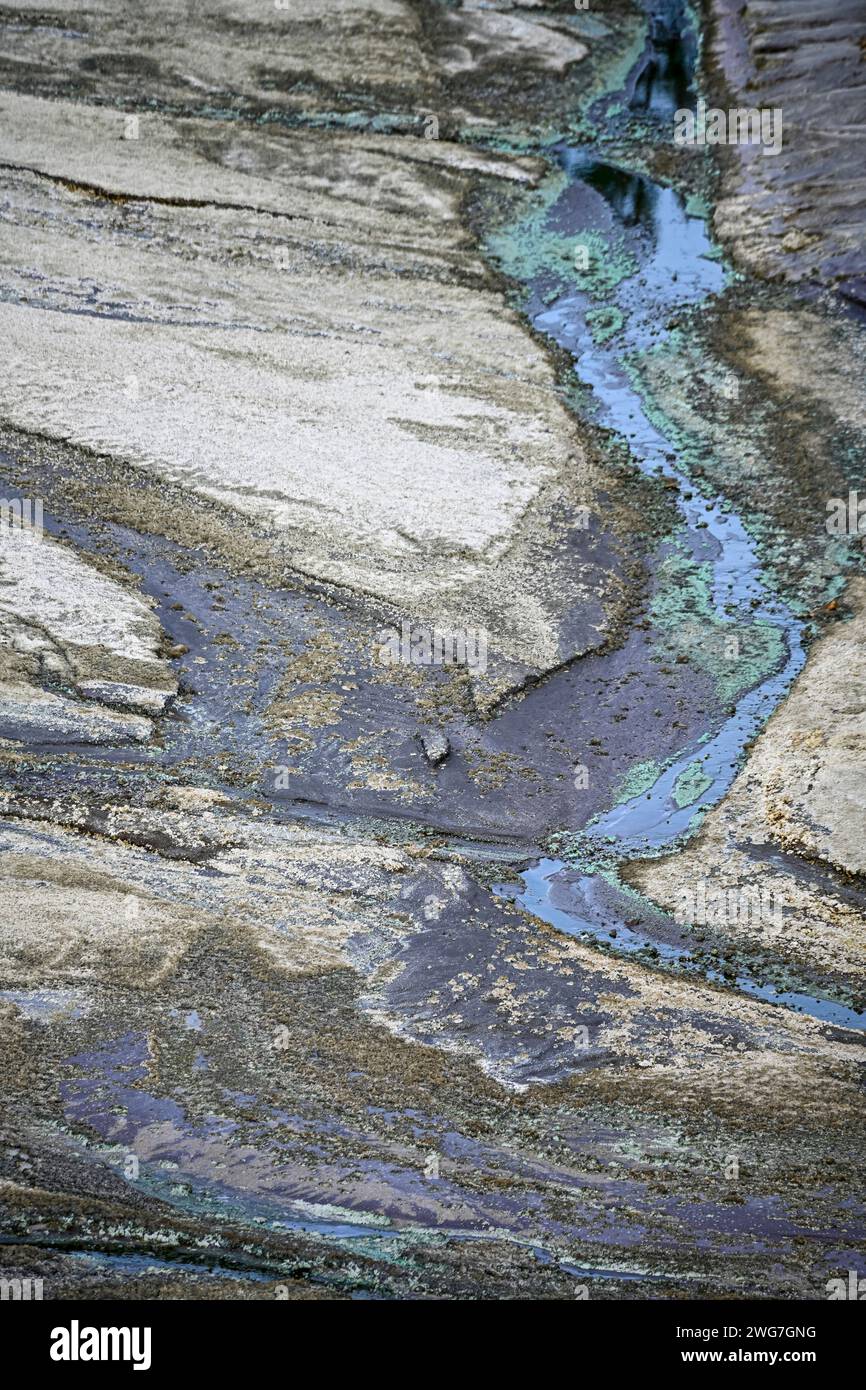 Formaciones rocosas naturalmente estriadas con rastros de agua ácida azul-verde en la región del Río Tinto Foto de stock