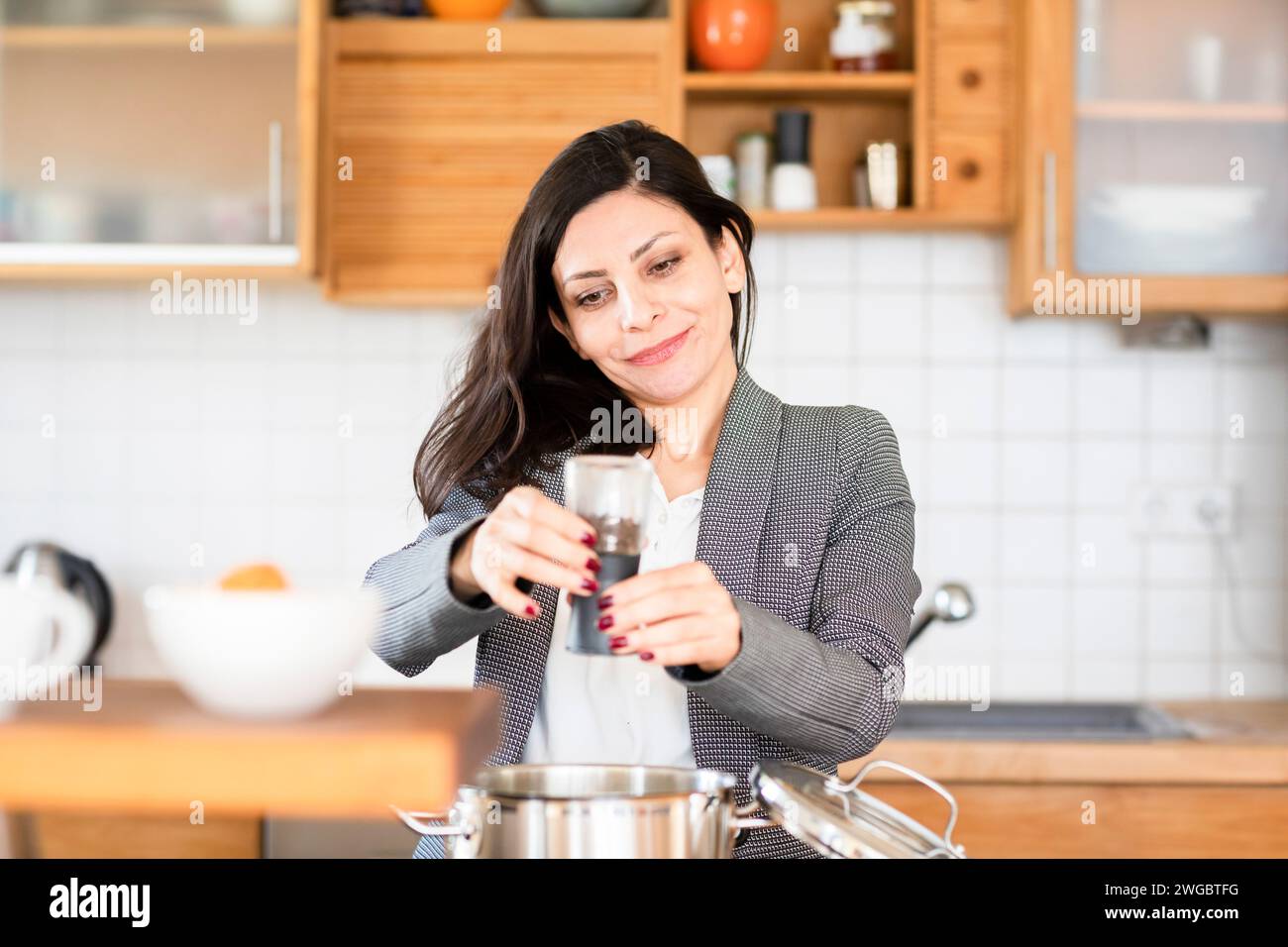 Mujer de pie en la cocina haciendo comida Foto de stock