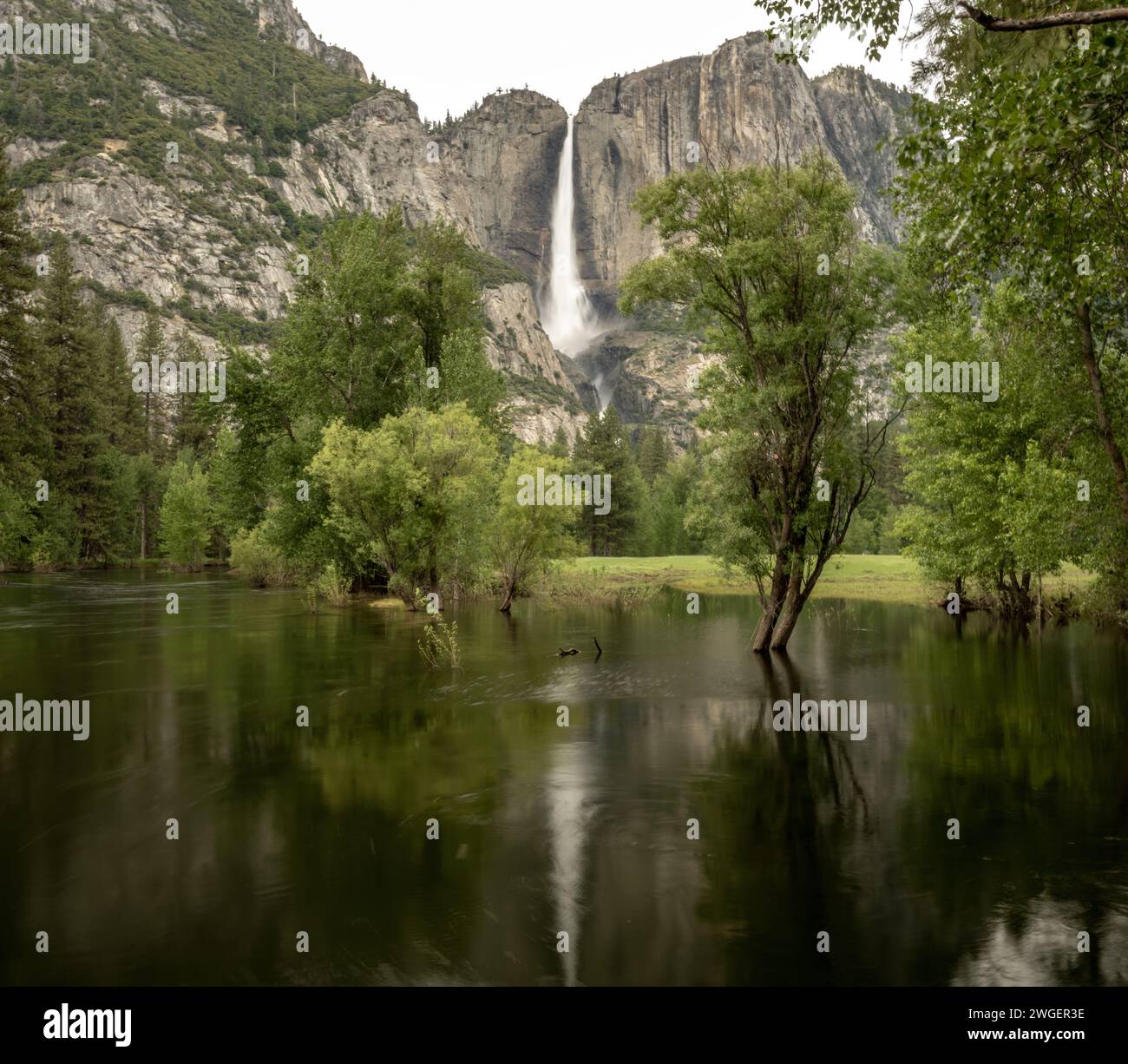 El río Merced inunda el valle de Yosemite con la caída del Alto Yosemite en el fondo Foto de stock