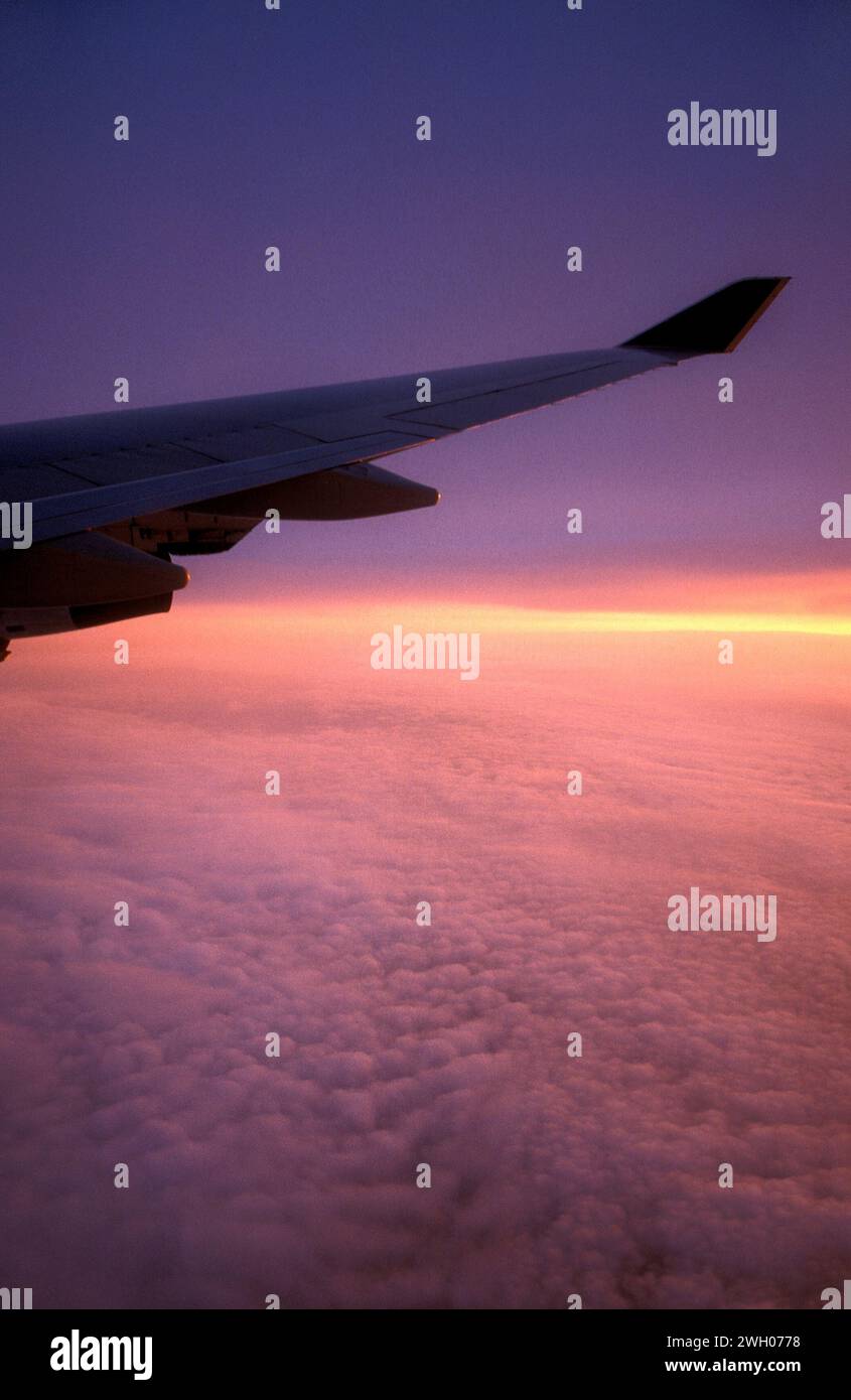 Amanecer a través del cielo nublado desde aviones Foto de stock