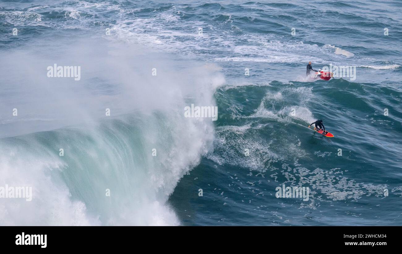 Un surfista y un jet ski en una gran ola, Nazare, Portugal Foto de stock