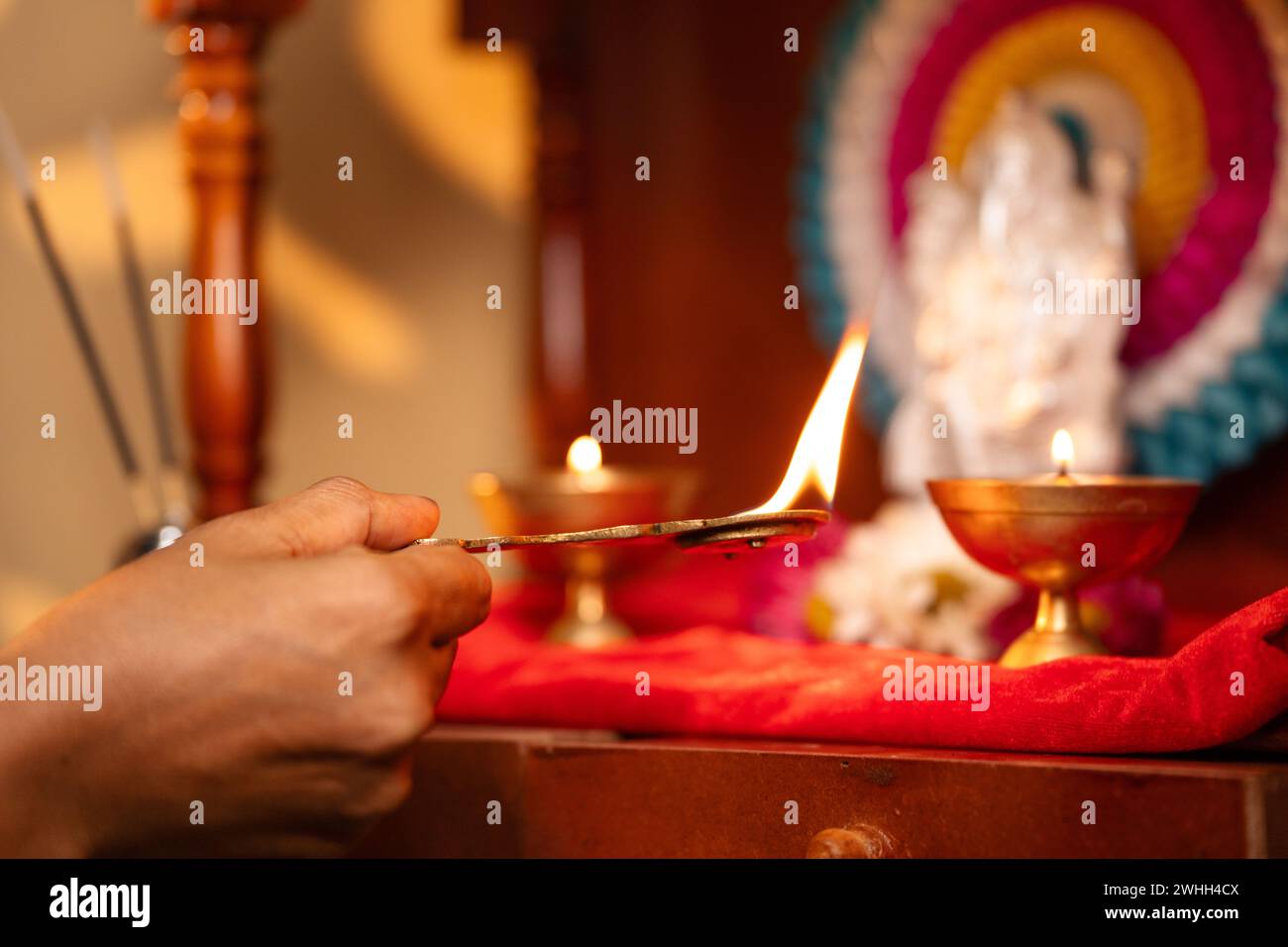 Primer plano de las manos de la mujer adorando ofreciendo aarthi a dios durante la mañana - concepto de rituales, costumbre tradicional y espiritualidad. Foto de stock