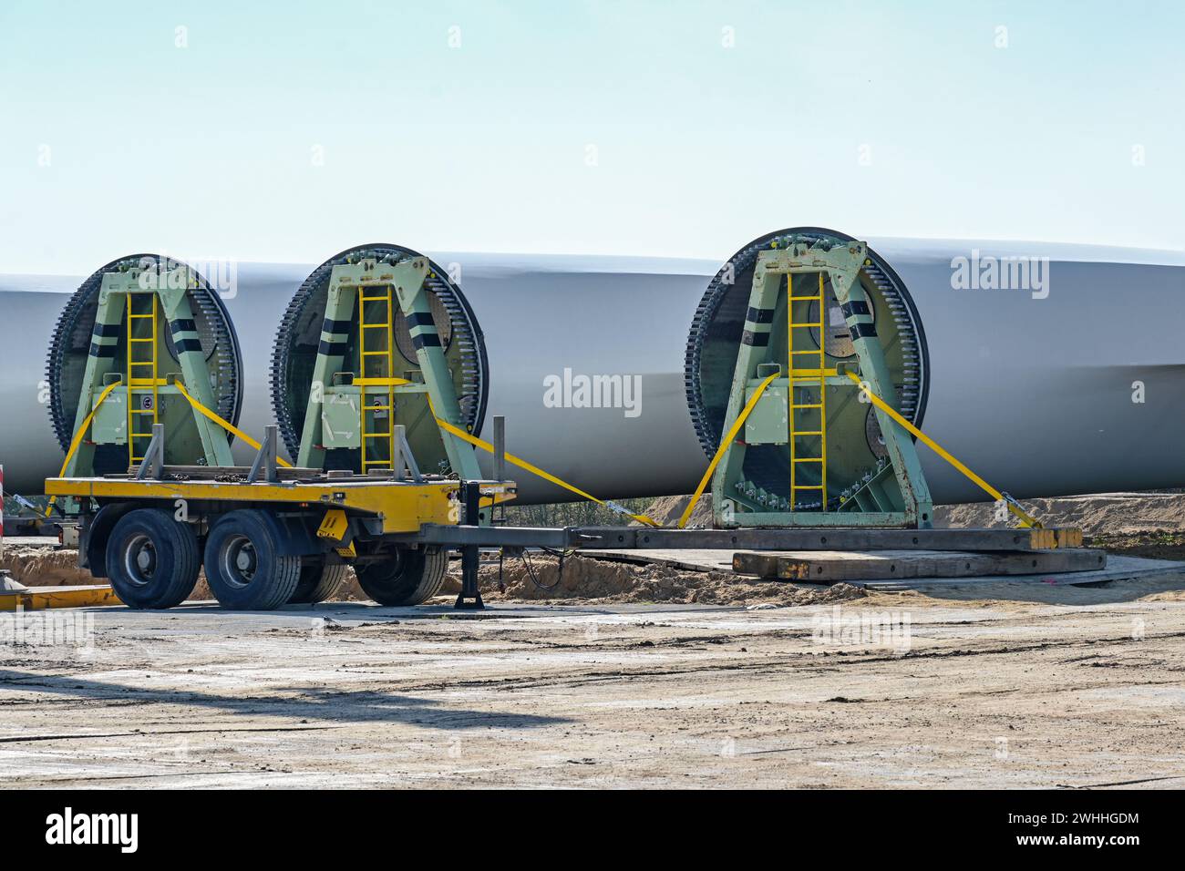 Las palas de la turbina eólica se almacenan cerca del sitio de construcción, industria pesada en preparación para una planta de energía renovable, cop Foto de stock