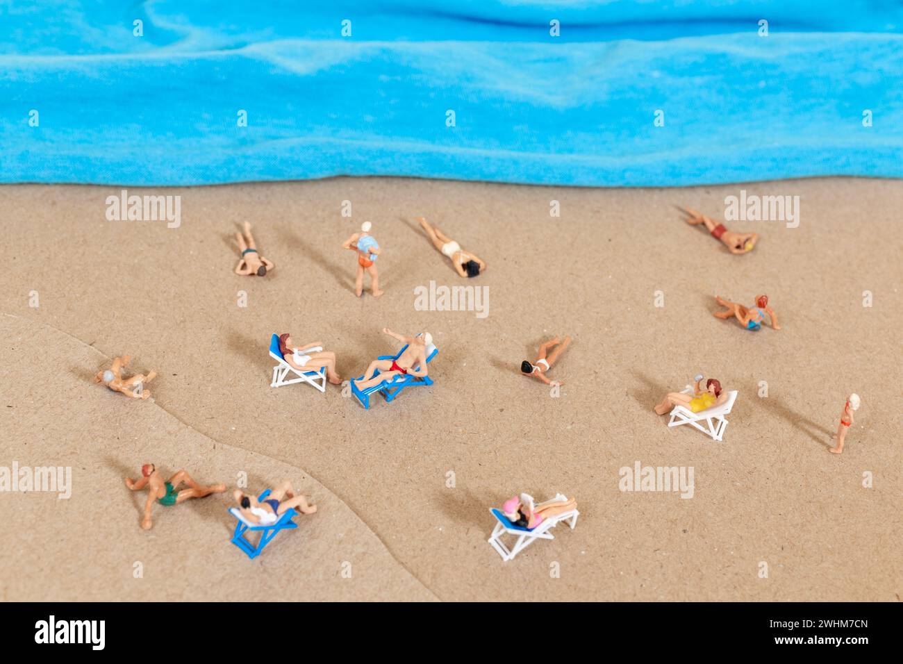 Una persona pequeña en un traje de baño se relaja en la playa en el verano Foto de stock