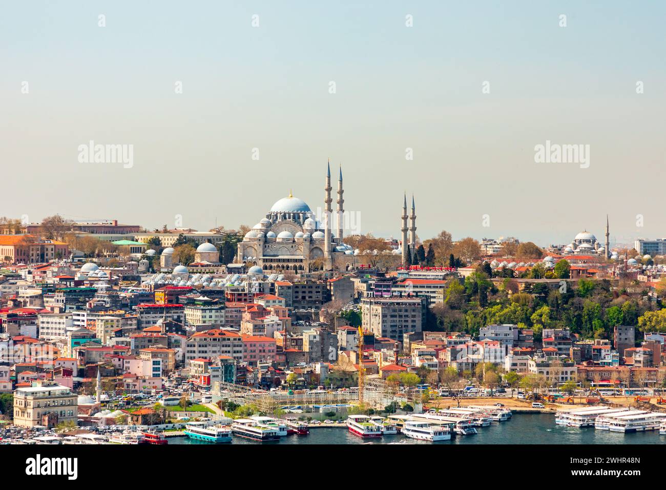 Vista sobre la mezquita de Suleymaniye en la parte europea de Estambul, Turquía, Turkiye, panorama en día soleado. Casas coloridas con techos rojos. Foto de stock