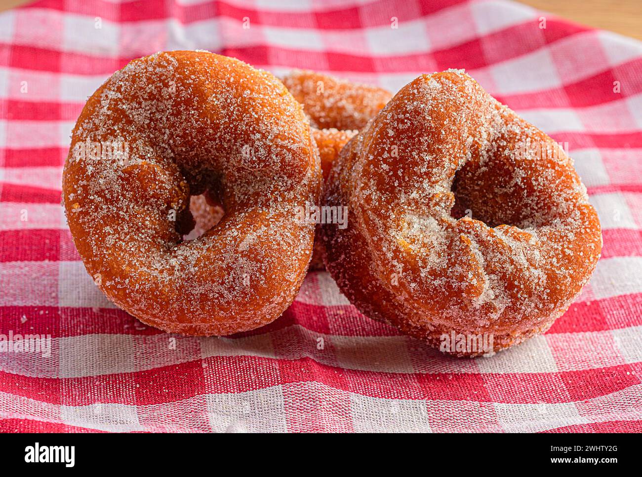 Dos donuts vidriados descansando en un mantel a cuadros Foto de stock