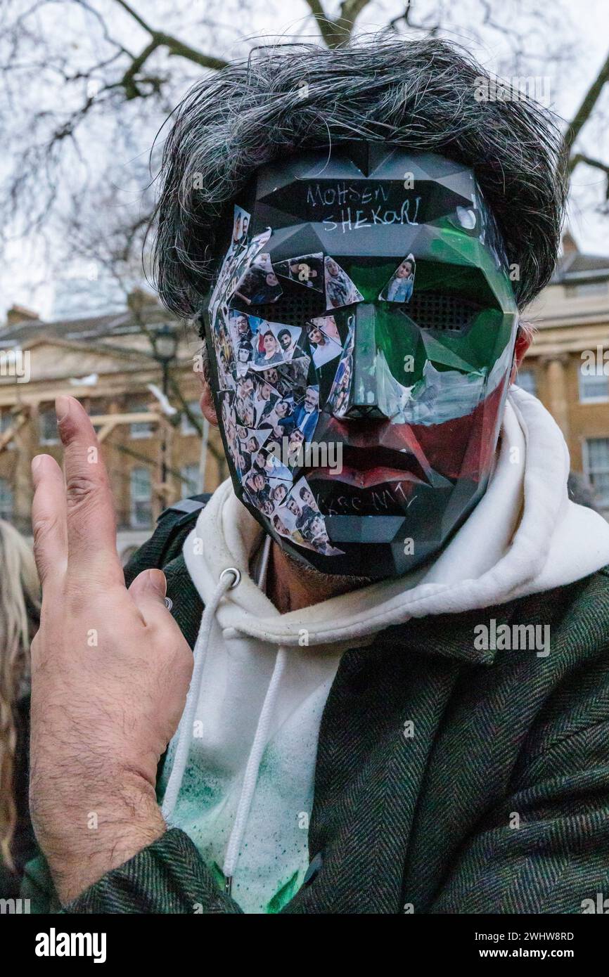 Whitehall, Londres, Reino Unido. 11 de febrero de 2024. Un hombre con una máscara facial en un evento de Stage of Freedom donde la diáspora británica iraní y sus partidarios protestan contra el régimen en el 45 aniversario de la Revolución de 1979 en una manifestación de Stage of Freedom en Londres. La mayoría de los iraníes consideran al Cuerpo de la Guardia Revolucionaria Islámica (CGRI), que tiene un papel en casi todos los aspectos de la política y la sociedad iraníes, como un obstáculo para la vida que quieren vivir. Foto de Amanda Rose/Alamy Live News Foto de stock