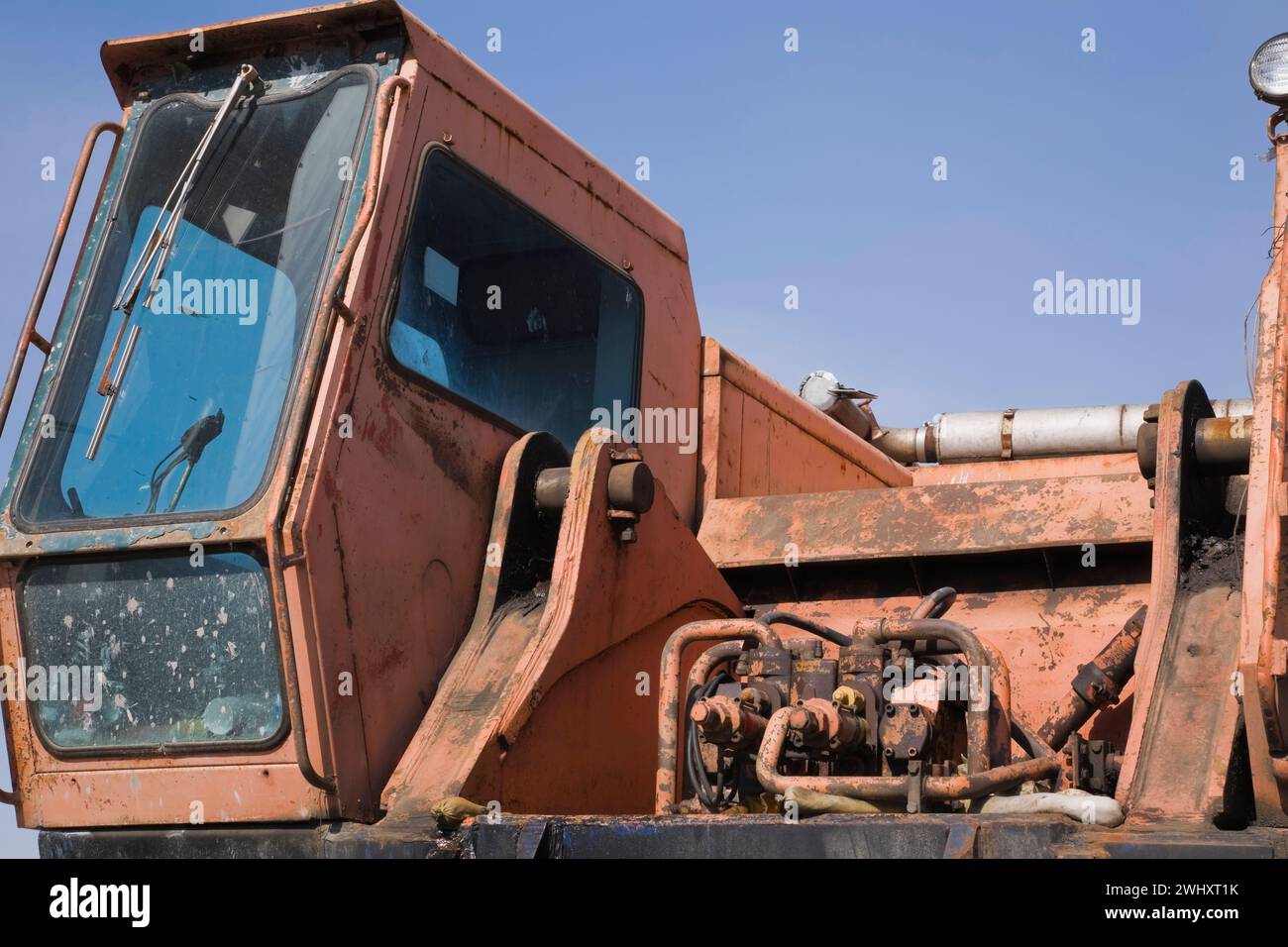 Cabina del conductor y sistema hidráulico en excavadora vieja y abandonada. Foto de stock