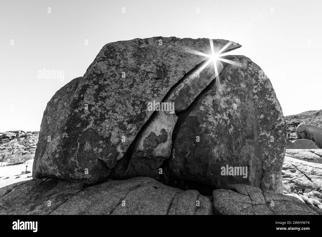 Parque Nacional Joshua Tree, Brillante del sol, Rocas agrietadas, Brillo de la lente, Espigas solares, paisaje desértico, luz del sol a través de las rocas Foto de stock