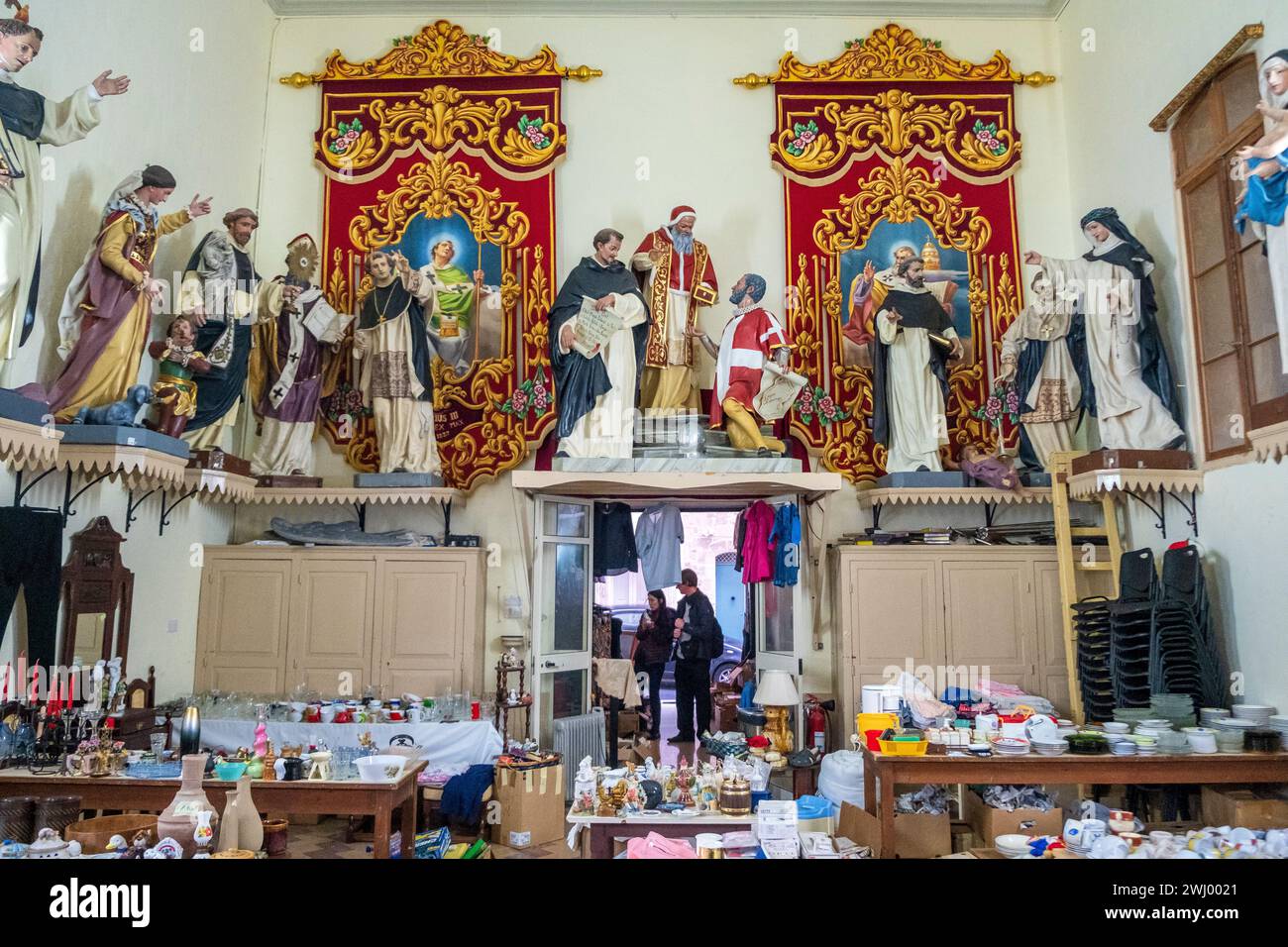 Estatuas de santos católicos sobre una tienda de segunda mano en La Valeta, Malta Foto de stock