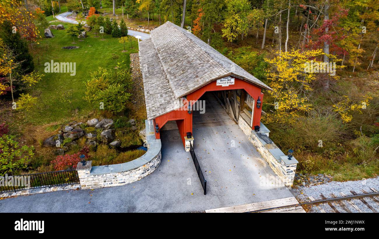 Vista aérea de un puente cubierto Burr Truss cruzando un arroyo en un día de otoño Foto de stock