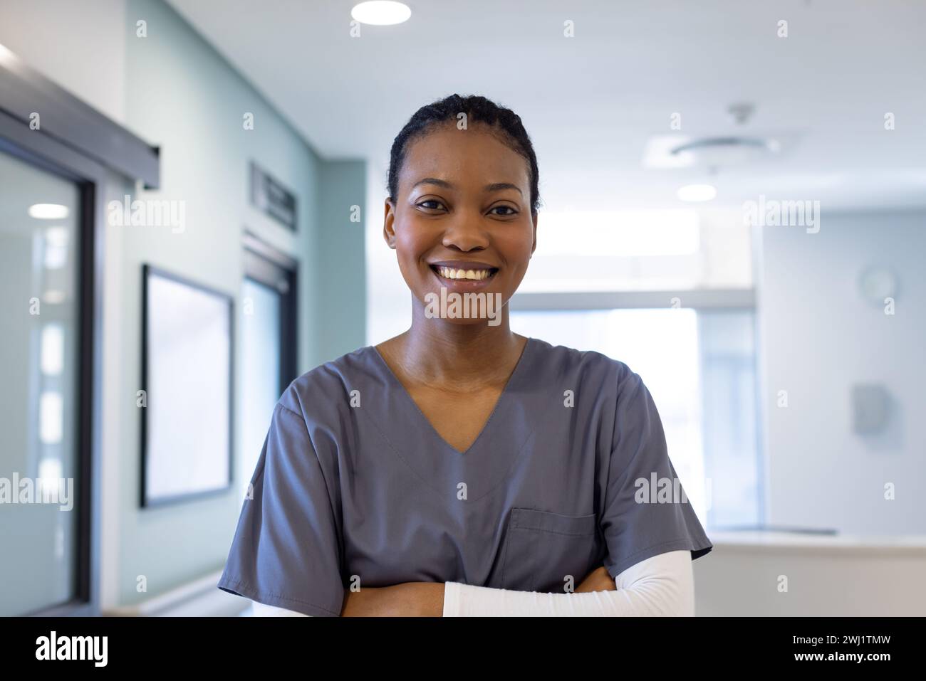 Retrato del médico femenino afroamericano feliz en el pasillo del hospital Foto de stock