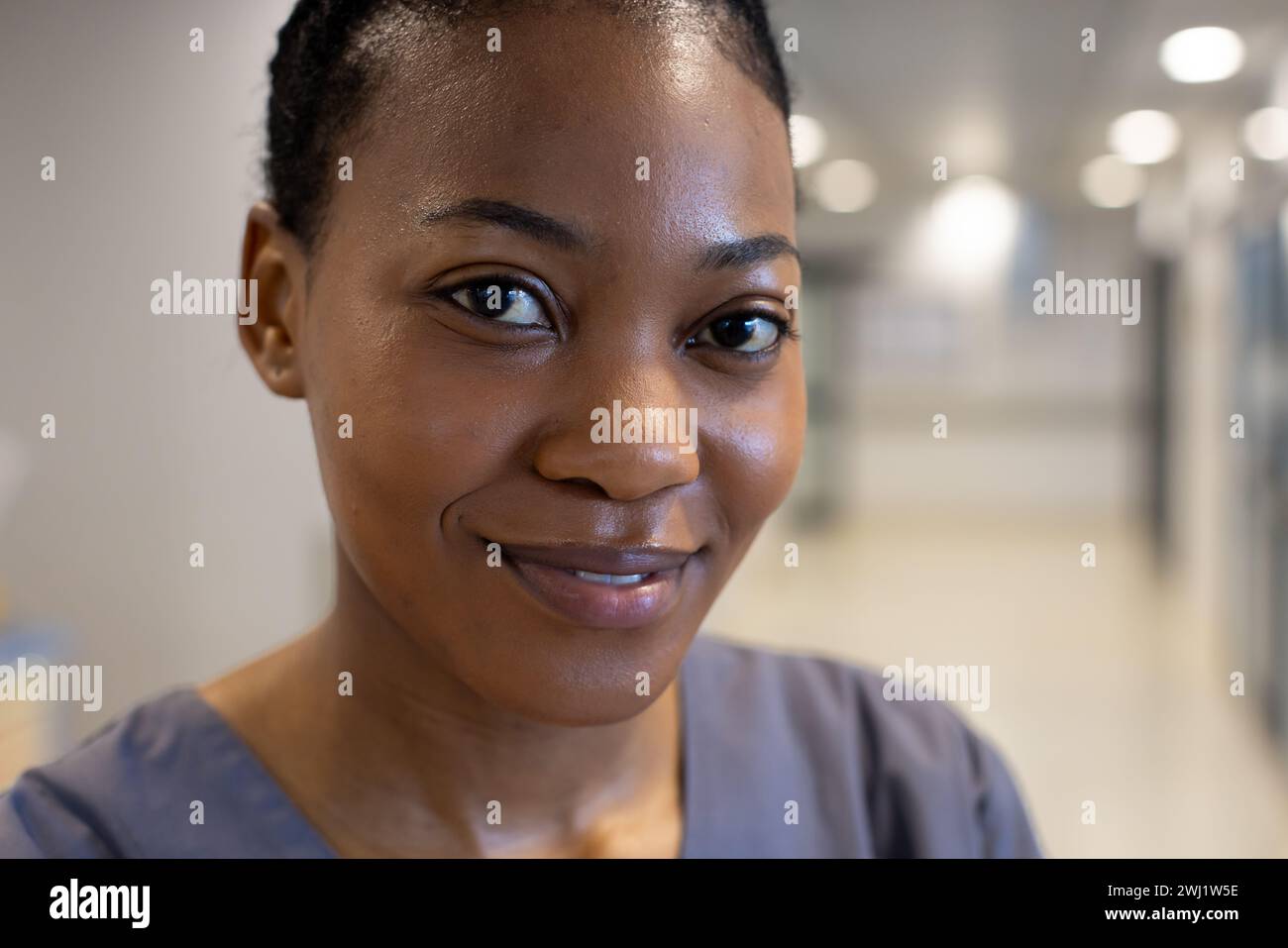 Retrato del médico femenino afroamericano feliz en el pasillo del hospital Foto de stock