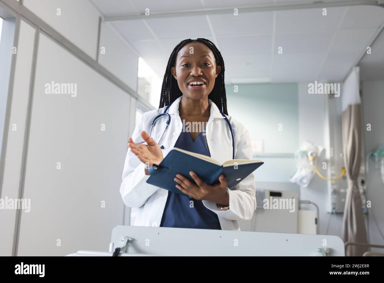 Médico femenino afroamericano feliz que tiene videollamada en la habitación del hospital Foto de stock