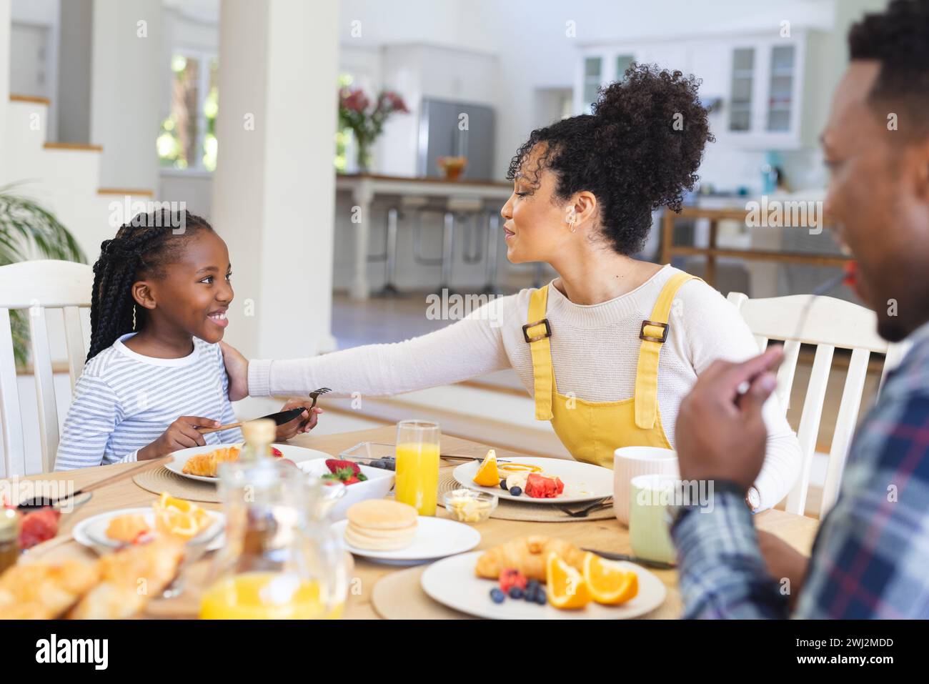 Familia afroamericana feliz que tiene fruta fresca snack en el comedor en casa, espacio de copia Foto de stock