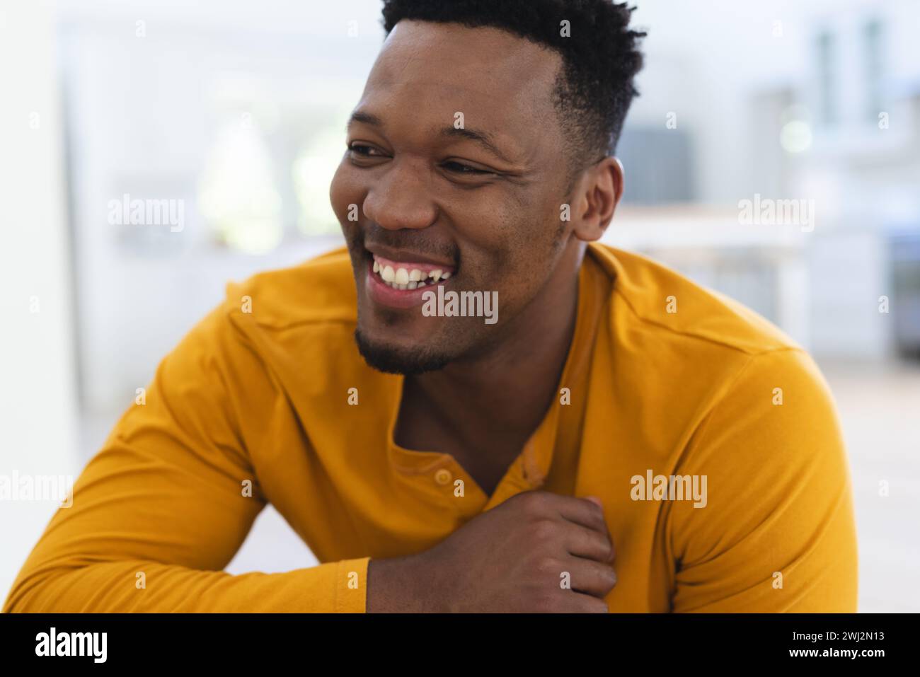 Hombre afroamericano feliz sentado en las escaleras en casa, cara de cerca, espacio de copia Foto de stock