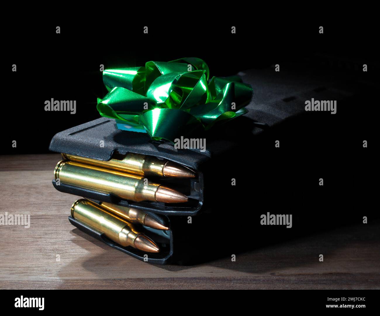 Arco verde en la parte superior de dos cargados de alta capacidad AR-15 revistas en una mesa como regalo para un propietario de armas. Foto de stock