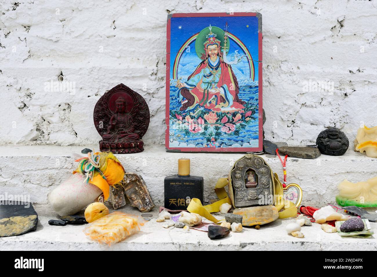 Estatuas budistas y reliquias sagradas se dejan como ofrendas en los escalones de la stupa del Paso Karo-La, o chorten, en las montañas del Himalaya de la Región Autónoma del Tíbet Foto de stock