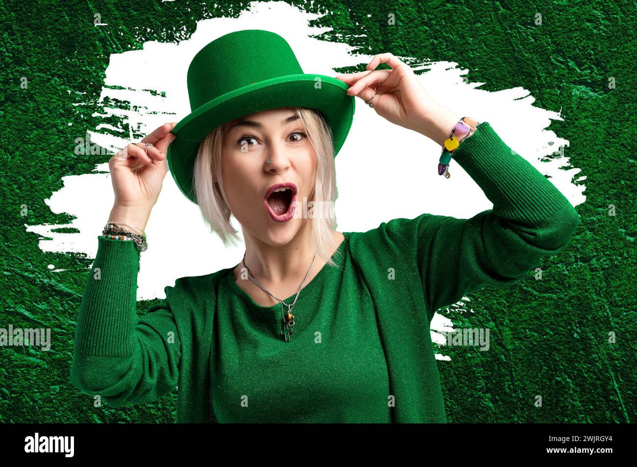 St. Patricks Day Mujer. Hermosa mujer sonriente con sombrero verde. Fondo del día de San Patricio con tréboles Foto de stock