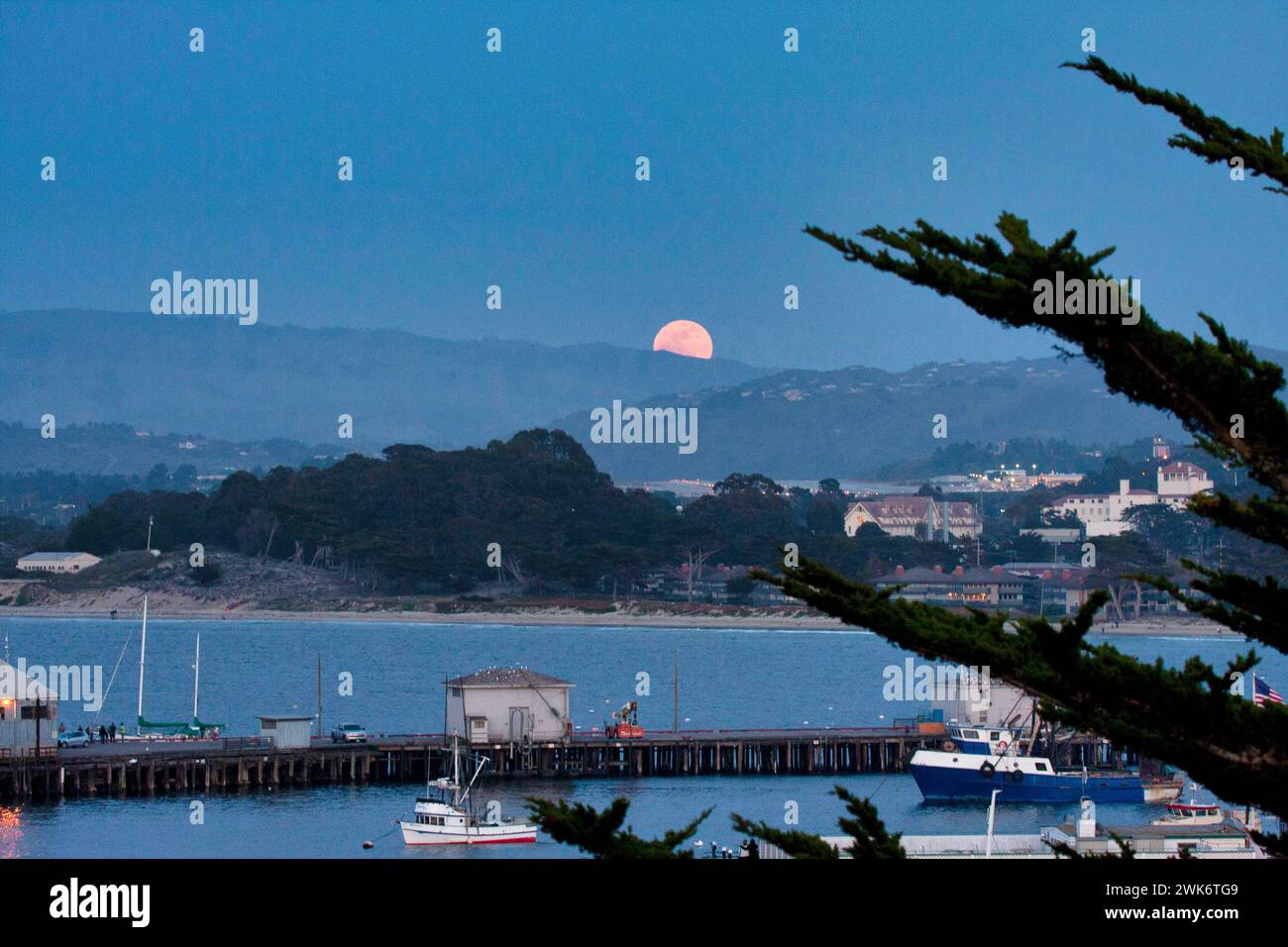 Super luna puesta sobre el muelle número 2 de Monterey. Foto de stock