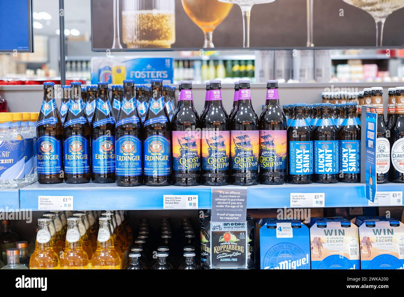 Una exhibición del estante del supermercado del reino unido de cervezas y lagers no alcohólicas. La exhibición incluye botellas de Nave Fantasma no alcohólica IPA y Luck Saint Lager Foto de stock