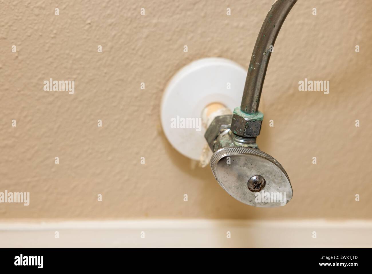 Casa residencial baño wc válvula de cierre de agua. Reemplazo de la vieja tubería de suministro de la pared del baño con fugas de la tubería de la válvula. Foto de stock