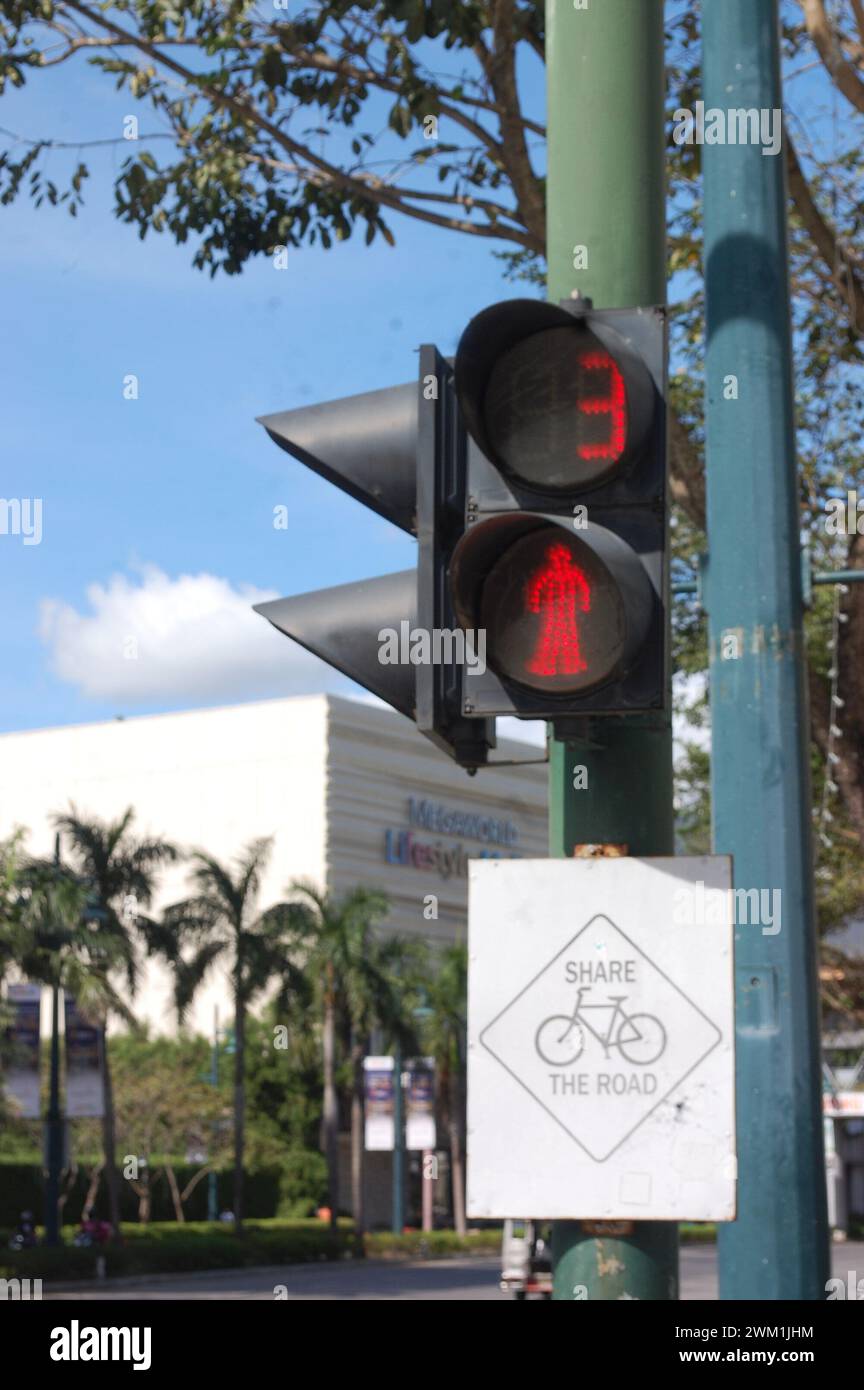 Luz de calle roja con señal de bicicleta y hombre que camina en luz de calle Foto de stock