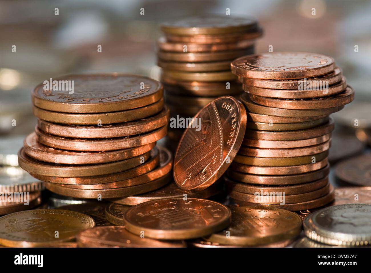 Tres pilas de cambio pequeño principalmente en dos peniques y un penique piezas encima de otro cambio pequeño en moneda esterlina Foto de stock