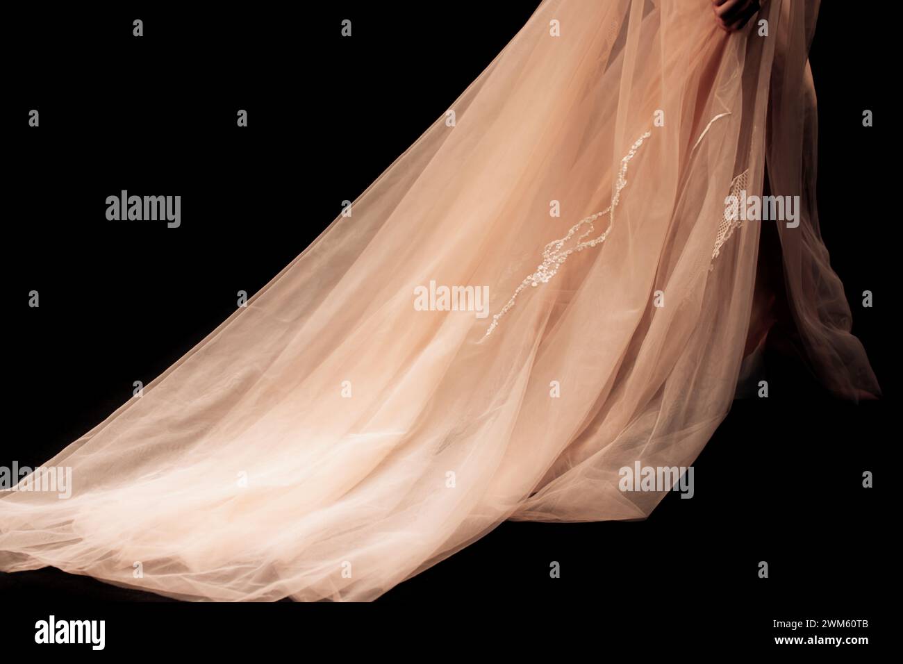 Detalles de larga noche beige chic falda sobre un fondo negro. Moda femenina ropa elegante Foto de stock