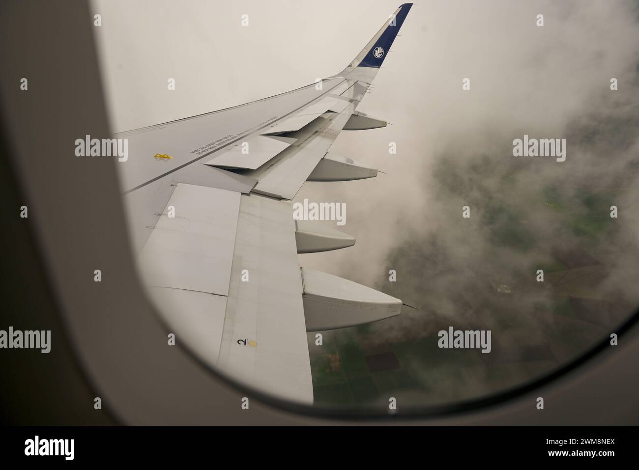 Vista desde la ventana comercial del avión sobre el ala en el jet de Air France / KLM descendiendo en la Francia nublada Foto de stock