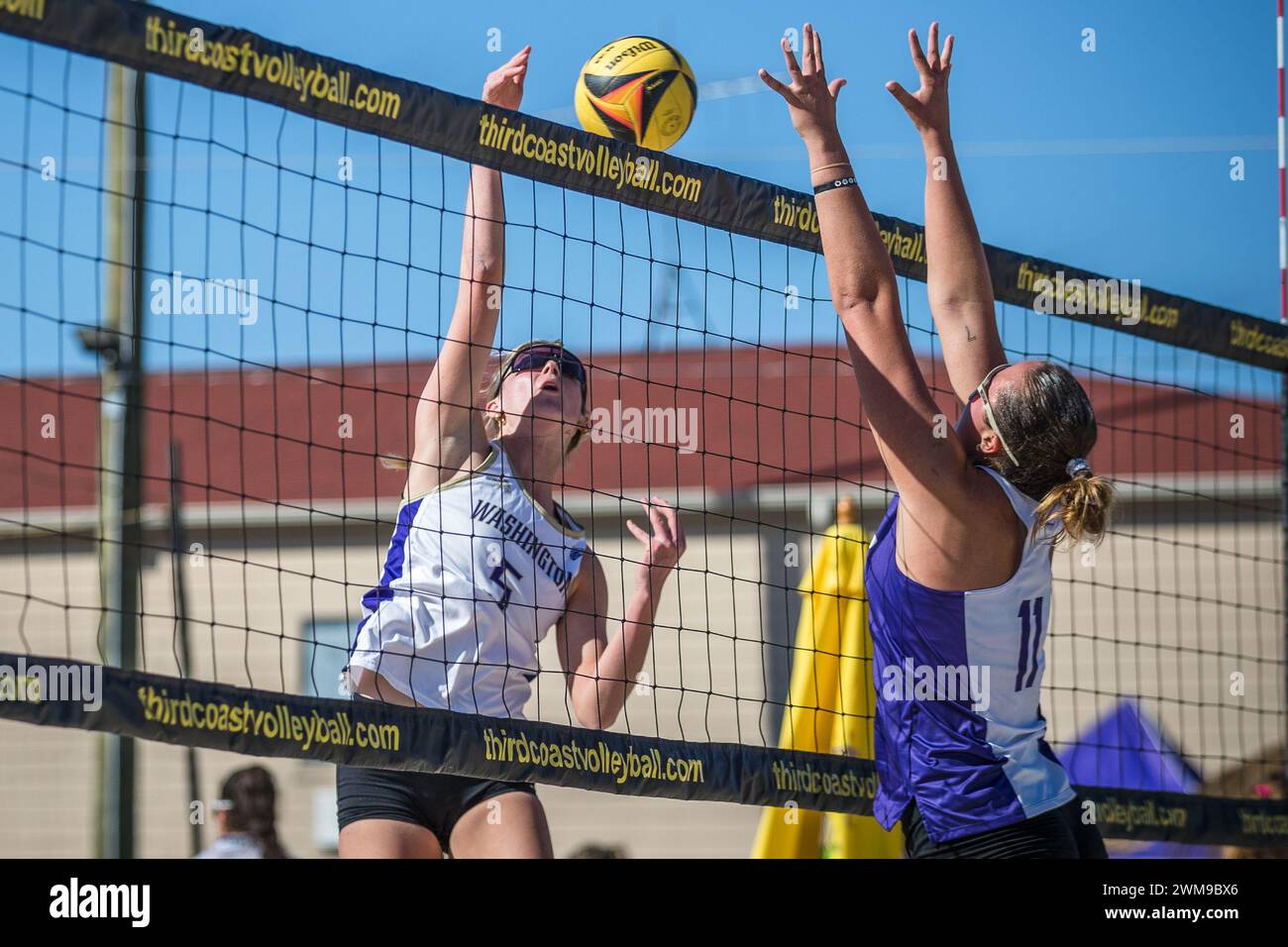 Houston, Texas, Estados Unidos. 23 de febrero de 2024. Washington Huskies Brooke Balue (5) pinta el balón mientras TCU Horned Frogs Emma Glagau (11) defiende durante el partido de voleibol playa de la NCAA entre los TCU Horned Frogs y los Washington Huskies en el 2024 Third Coast College Classic organizado por la Universidad Cristiana de Houston en Third Coast Volleyball en Houston, Texas. Prentice C. James vía Cal Sport Media/Alamy Live News Foto de stock