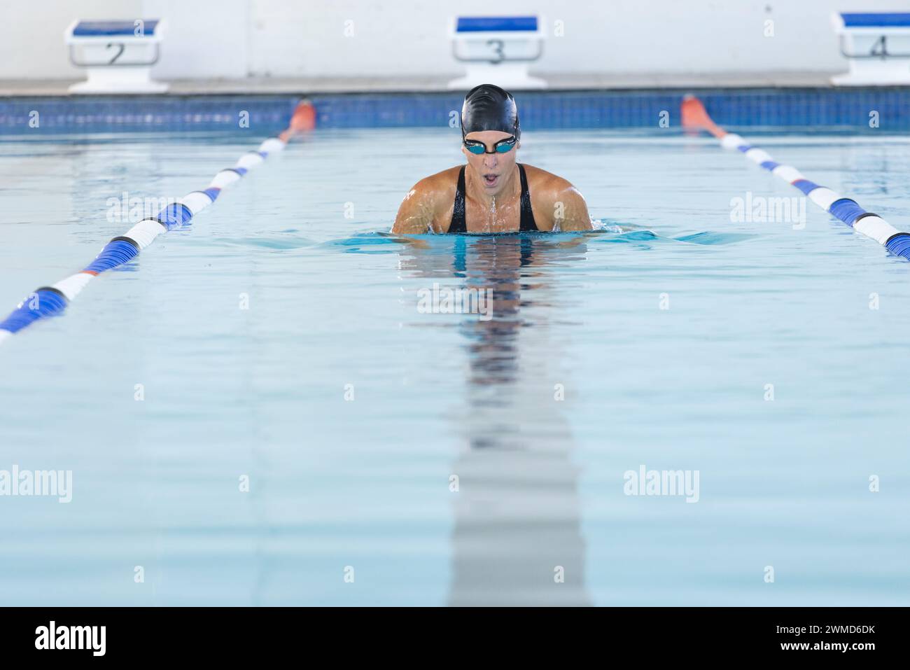 Atleta caucásica nadadora nadando en una piscina Foto de stock